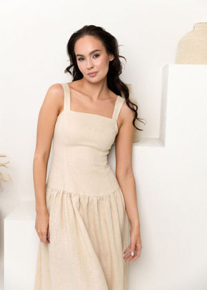 Woman wearing a beige linen dress against a white background
