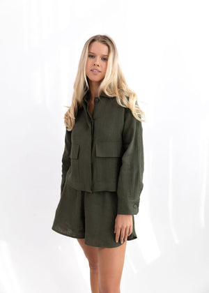 Woman wearing a green jacket and skirt set on a white background