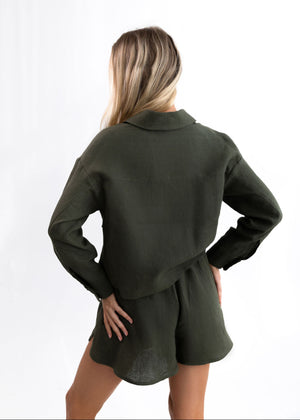 Person wearing a green outfit with a matching jacket and shorts on a white background