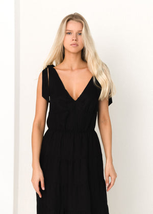 Woman wearing a black linen dress against a white background