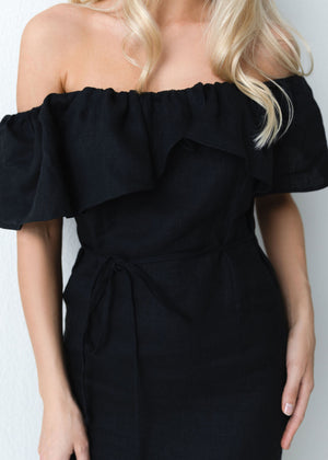 Black off-shoulder linen dress worn by a person with blonde hair on a plain background